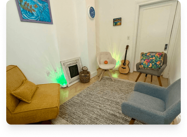 The therapy room for children and teens. A guitar, soft seating, and warm light.